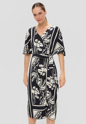 Robe portefeuille à motif de feuilles noir et blanc, manches courtes, décolleté en V et ceinture à la taille. Tissu lisse avec une coupe mi-longue.