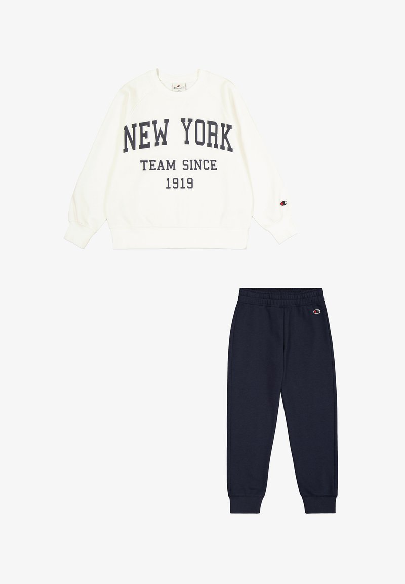 Sudadera cremosa con "NEW YORK TEAM SINCE 1919" impresa en un azul marino oscuro, combinada con pantalones jogger azul marino, ambos con un tejido suave y puños elásticos.