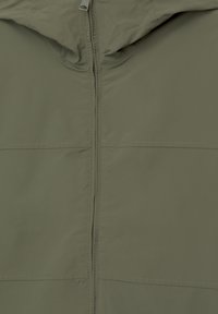 Veste vert olive avec fermeture éclair à l'avant et capuche, montrant un tissu lisse et des détails de couture.