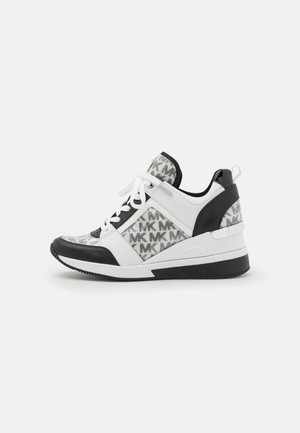 Biała i czarna sneaker na koturnie z panelami z materiału z wzorem logo, białe sznurówki i pętelka na pięcie, pokazana z profilu.