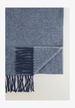 Blauwe deken met een visgraatpatroon en een gestructureerde afwerking; heeft een donkerblauwe franjerand langs één kant en een omgevouwen hoekdetail.