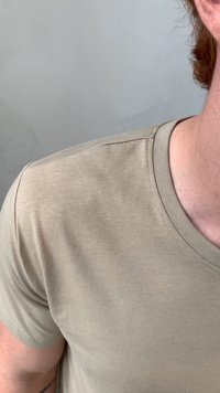 Beige T-shirt met korte mouwen, gemaakt van zachte, lichte stof. Heeft een ronde hals en een subtiele ribbelstructuur.