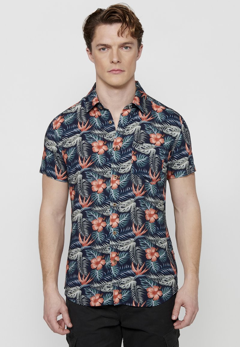 Kortegloed button-up shirt in marineblauw met levendige bloemen- en bladvormen in rood, groen en beige; voorzien van een borstzak en een ontspannen fit.