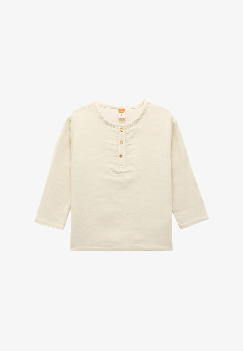 Camisa de manga larga de color beige claro, hecha de una tela suave, con un cuello redondeado y tres botones frontales con un acabado texturizado.