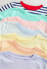 Sept t-shirts à col rond pliés, aux motifs pastel et rayés, disposés en une pile superposée de haut en bas.