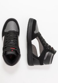 Höga sneakers med svart ovandel och grå detaljer, perforerat tåbox, vit sidologga och strukturerad svart sula.