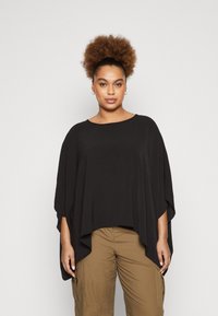 Black, oversized poncho top with a round neckline and flowing sleeves. Lightweight fabric with a textured surface. Casual fit.