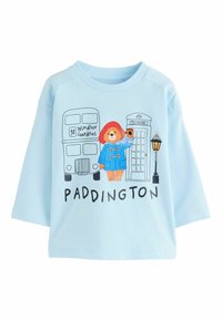 Svetlo modrý bavlnený sveter s Paddingtonom, dvojposchodovým autobusom a telefónnou búdou. Krátke rukávy a voľný strih.