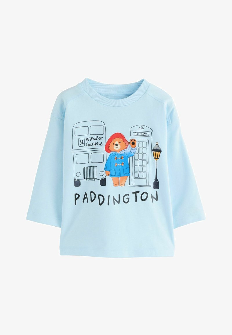 Gaiši zils kokvilnas džemperis ar Paddingtonu Lāci, divstāvu autobusu un telefona būdiņu. Īsas piedurknes un brīvs piegriezums.