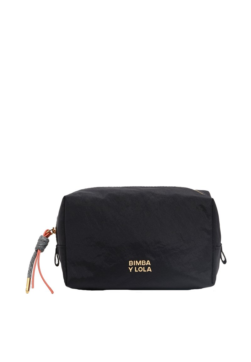 Bolsa cosmética de nylon negro con forma rectangular, que presenta un logo dorado, un adorno de borlas rosas y grises, y cierre de cremallera.