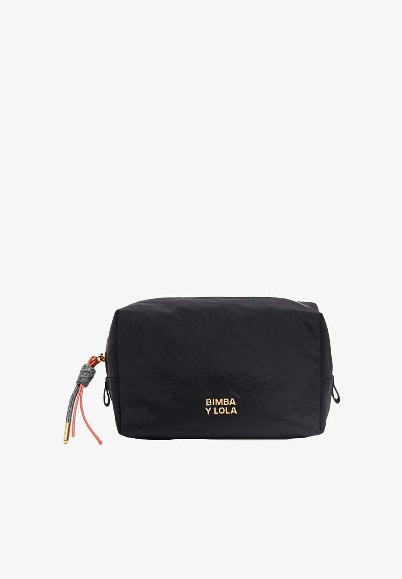 Bolsa cosmética de nylon negro con forma rectangular, que presenta un logo dorado, un adorno de borlas rosas y grises, y cierre de cremallera.