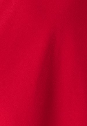 Raudona medžiaga, lygi tekstūra su šiek tiek matiniai paviršių. Vienoda spalva, be matomų raštų ar detalėse. Lygi drapiruotė ir minkšta išvaizda.