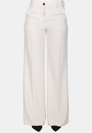 Pantaloni bianchi a gamba larga con sottili righe verticali nere, passanti per cintura, bottone frontale e tasche laterali, indossati con scarpe nere appuntite.