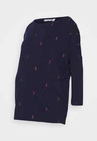 Těhotenský top v námořnické modré barvě s tříčtvrtečními rukávy a kulatým výstřihem, zdobený rozptýlenými červenými peřím a knoflíkovými detaily na rameni.