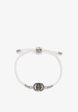 Bracelet blanc ajustable avec un charme couronne en argent entouré de petites pierres claires et de embouts métalliques argentés.