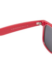 Ochelari de soare din plastic roșu cu lentile întunecate. Caracteristici un sistem de balama robust și text gravat care indică protecția UV și categoria.