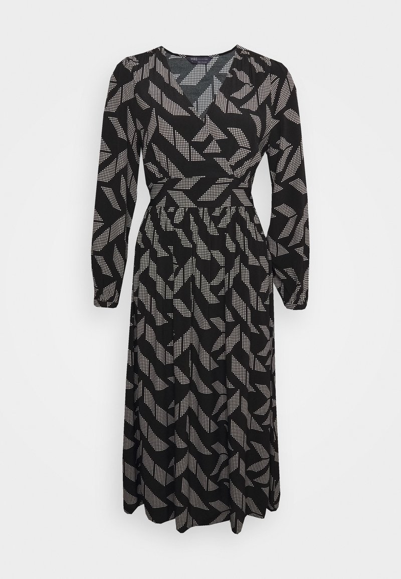 Vestido negro con mangas largas y escote en V. La tela tiene un patrón blanco geométrico. Cintura elástica con falda fluida.