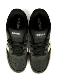 Czarne sneakersy Adidas z teksturowaną cholewką, białymi paskami po bokach i perforowaną częścią palców. Posiadają czarne sznurówki i logo na języku.