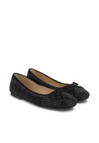 Ballerines noires avec un design clouté, bout arrondi et accent de nœud. Doublure intérieure lisse et semelle basse.