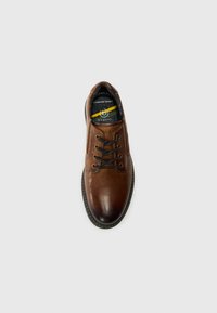 Brown leather shoe with rounded toe, black laces, stitching detail, and "Comfort Wide" label on the insole. Smooth texture with slight shine.