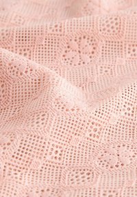 Ljust rosa spetstyg med geometriska och blommiga mönster, med en fin, öppen stickad textur och en mjuk, flexibel fall.