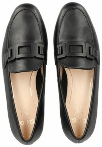 Mocasines de cuero negro con un acabado suave, punteras redondeadas y suela plana. Con detalle de tira negra mate a través del empeine.