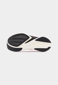 Σόλα αθλητικού παπουτσιού με μαύρα ελαστικά σχέδια πέλματος και λευκή ενδιάμεση σόλα σε απλό φόντο.