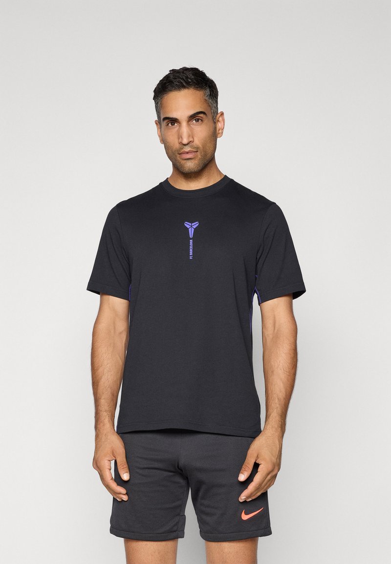 Zwarte sportieve t-shirt van zachte stof, met een paarse logo op de borst en contrasterende paarse accenten aan de zijkanten.