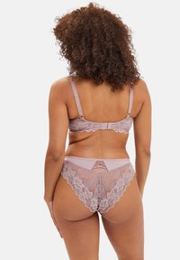 Soutien-gorge en dentelle et string assorti en mauve doux. Présente des motifs floraux complexes, des bords festonnés et des détails croisés à l'arrière.