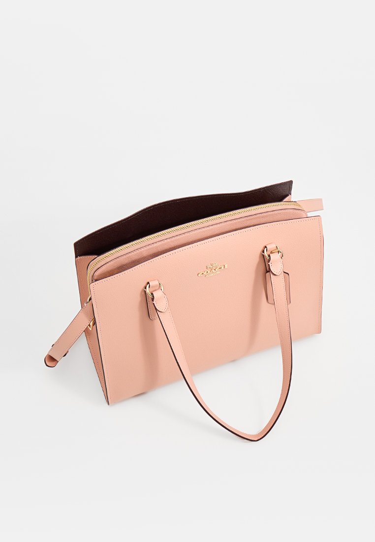 Rosa läderhandväska med en strukturerad design, dubbelhandtag och ett guldblixtlås; har brunt inre foder.