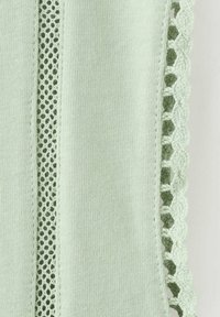 Tissu vert clair avec bande verticale en maille et bordure en dentelle crochetée festonnée sur le bord.