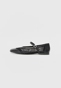 Black flat shoe with a rounded toe, featuring a mesh side panel and a strap with a buckle. Smooth leather toe cap and heel.