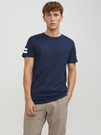 Marineblå bomulds t-shirt med rund halsudskæring og korteærmer. Har hvide striber på venstre ærme. Casual pasform med en glat tekstur.