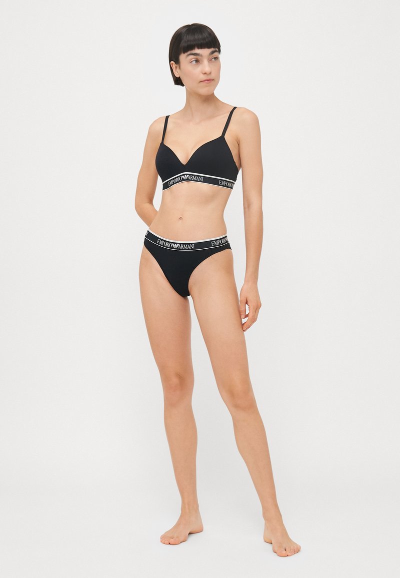 Zwart lingerieset met een naadloze bh met verstelbare bandjes en een V-hals, gecombineerd met bijpassende hoog uitgesneden slipjes, beide met een logo-bundel.
