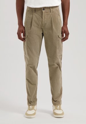 Khaki corduroy cargo bukser med plisseringer, sidelommer og smalle ben; parret med beige sneakers og en hvid t-shirt.