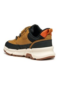 Sneaker in pelle marrone e sintetico nero con suola bianca spessa, caratterizzata da un accento arancione sul tallone e cuciture decorative.
