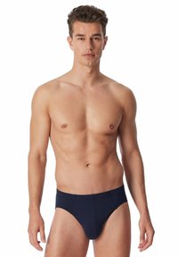 Slip da uomo di colore blu navy realizzati in tessuto morbido, con un design aderente, fronte sagomato e senza hardware visibile o decorazioni.