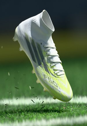 Scarpetta da calcio bianca con accenti gialli e grigi. Materiale sintetico high-tech, design a calzino e tacchetti visibili sulla suola.