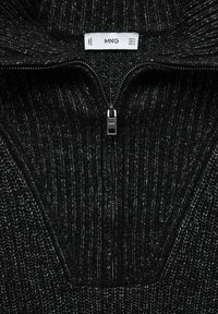 Schwarzer gerippter Strickpullover mit hohem Kragen und halblangem Reißverschluss. Mit einem Etikett, das den Markennamen und die Größeninformation enthält. Strukturierter Stoff.