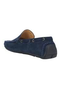 Mocassini slip-on in suede blu navy con profilo basso, cuciture decorative sul lato, occhielli in tonalità oro e suola in gomma testurizzata.