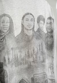 Szary T-shirt z monochromatycznym wzorem graficznym przedstawiającym cztery postacie z detalami twarzy i akcesoriami, umieszczonymi na fakturowanym tle.