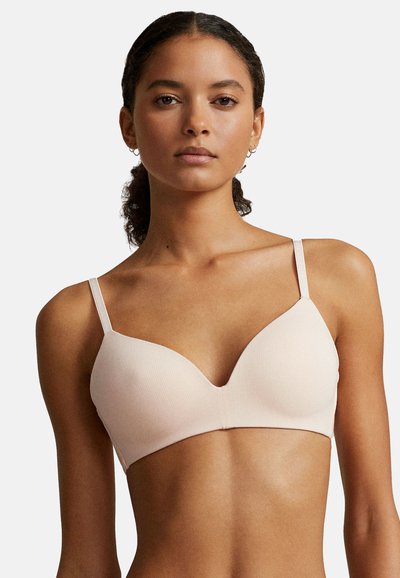 Ljusrosa ribbad behå med v-ringad design, justerbara tunna axelband och slät textur. Inga synliga detaljer eller dekorationer.