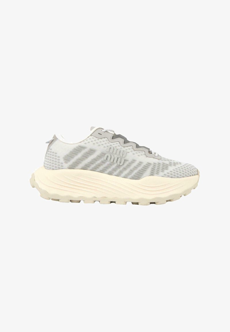 Baskets de sport gris clair et blanc avec une semelle beige épaisse et ondulée, une tige en mesh rayée subtile, un logo latéral et une fermeture à lacets.