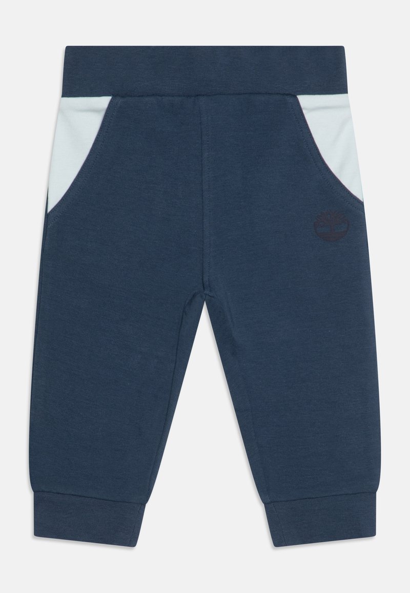 Pantalon bleu marine pour tout-petits avec poches latérales bleu clair, taille élastique, poignets côtelés et logo discret foncé sur la jambe droite.