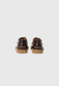 Chaussures en cuir marron avec bout rond, lacets en cuir et détails de couture en relief. Semelles en caoutchouc marron avec une finition texturée.