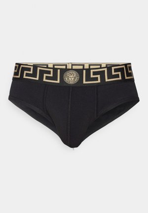 Culotte en coton noir avec une ceinture élastique à motif doré arborant un design de clé grecque et un emblème central.