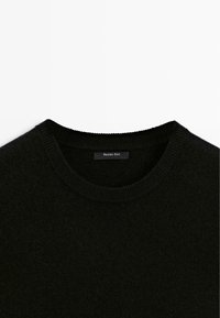 Schwarzer Wollpullover mit Rundhalsausschnitt und gerippten Bündchen. Verfügt über eine weiche Textur und ein kleines Etikett mit "Massimo Dutti", das innen eingenäht ist.