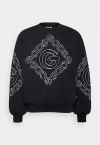 Sweat-shirt noir avec le logo "GCDS" en contour blanc en forme de losange sur le devant et les manches, avec une grande lettre "G" stylisée au centre.