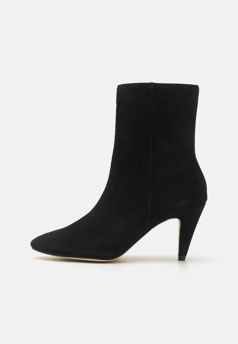 Bottine en daim noir avec un bout pointu et un talon aiguilles de 7,5 cm. Texture lisse et design minimaliste, avec des lignes épurées.