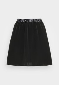 Falda de terciopelo negro con una cintura elástica que presenta el logo "CALVIN KLEIN JEANS" en blanco. Tiene una textura suave y una forma acampanada.